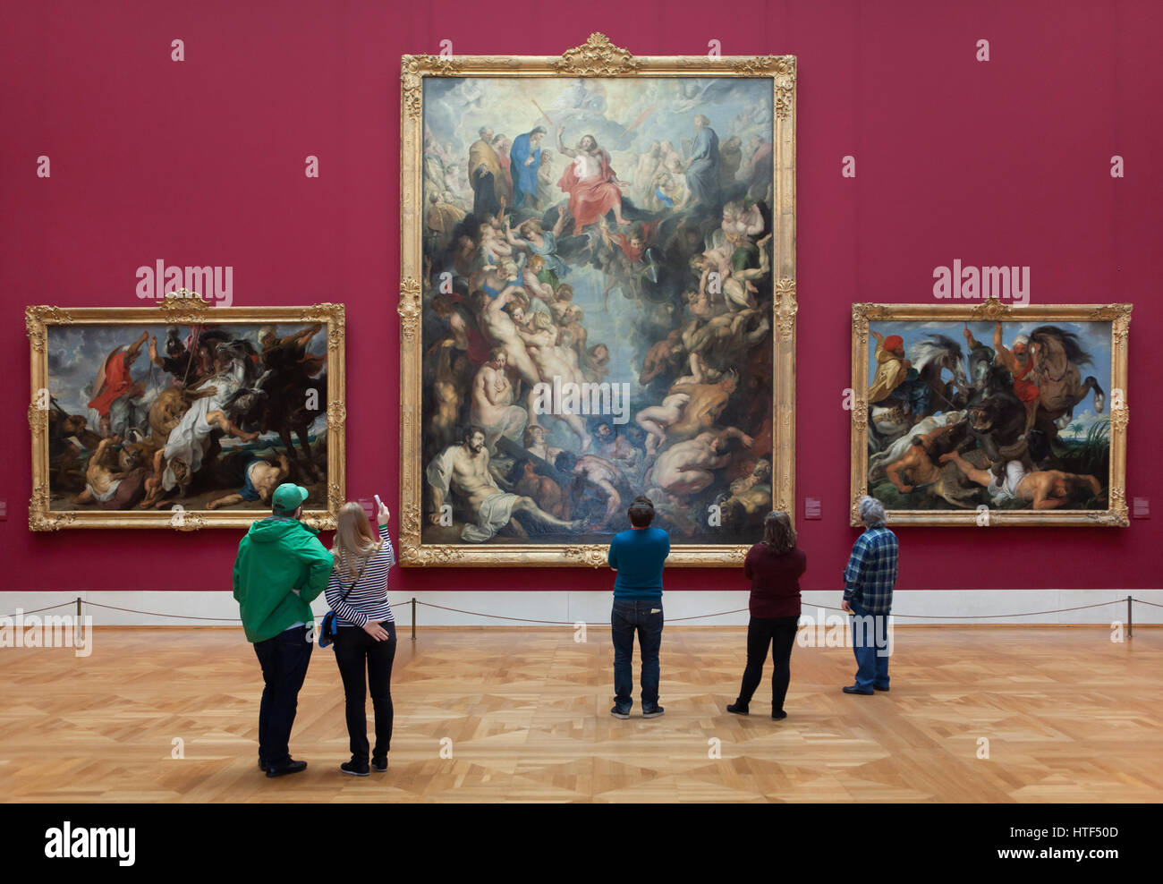 Visitors in front of the paintings by Flemish painter Peter Paul Rubens displayed in the Alte Pinakothek (Old Pinacotheca) in Munich, Bavaria, Germany. Paintings Lion Hunt (1621), The Great Last Judgement (1617) and The Hippopotamus and Crocodile Hunt (1616) by Peter Paul Rubens are depicted from left to right. Stock Photo
