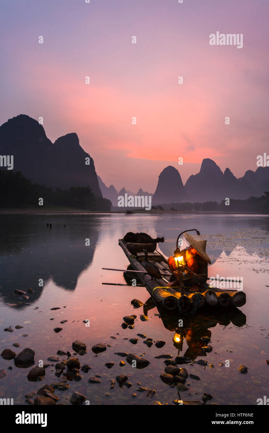 Cormorant fisherman prepares for night fishing on the Li River, near the town of Xingping in Guangxi province, China. This area is renowned for its Ka Stock Photo