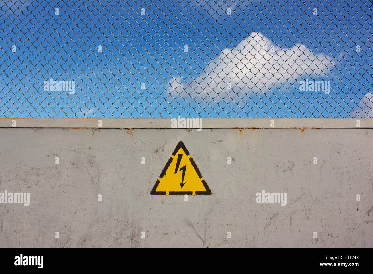 Obstruction to mark unsafe, high voltage and grid. Danger of death. The sky behind the fence Stock Photo