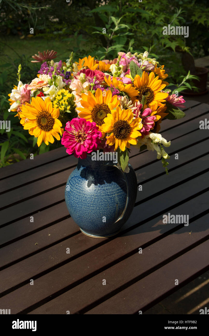 A flower bouquet arranged in a blue vase. Stock Photo