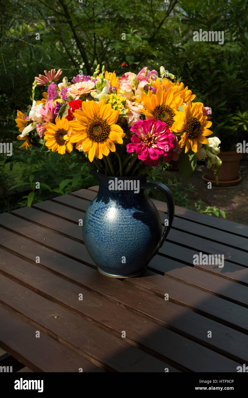 A flower bouquet arranged in a blue vase. Stock Photo