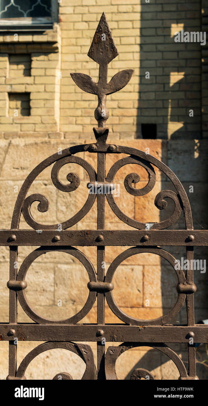 Old metal fence on a background of a wall Stock Photo - Alamy