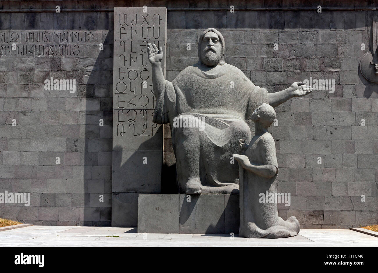 Sculpture of Mesrop Mashtoc and Koryun, in front of Matenadaran.On the wall: the letters of the Armenian alphabet Stock Photo
