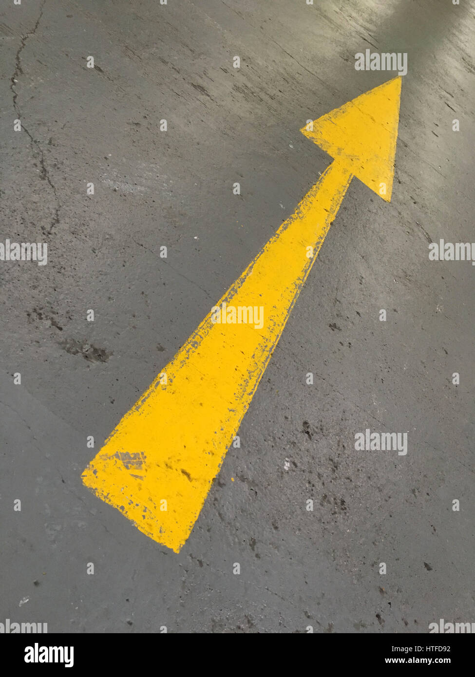 yellow arrow painted on the ground in a car park Stock Photo - Alamy