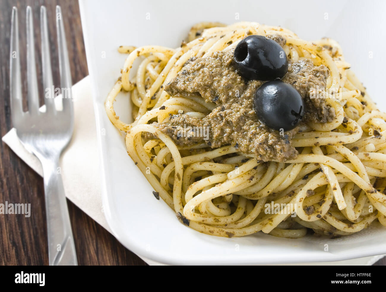 Spaghetti with black olive pesto Stock Photo Alamy