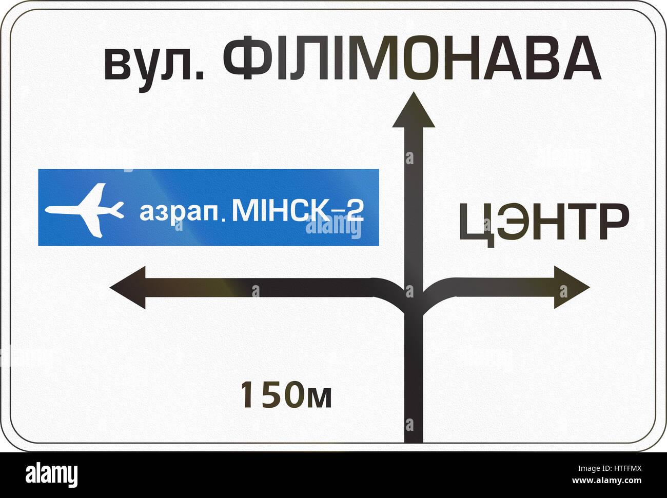 Belarusian direction road sign with directions to airport. The words mean Airport Minsk-2 (left), Filimonov Street (top) and center (right). Stock Photo