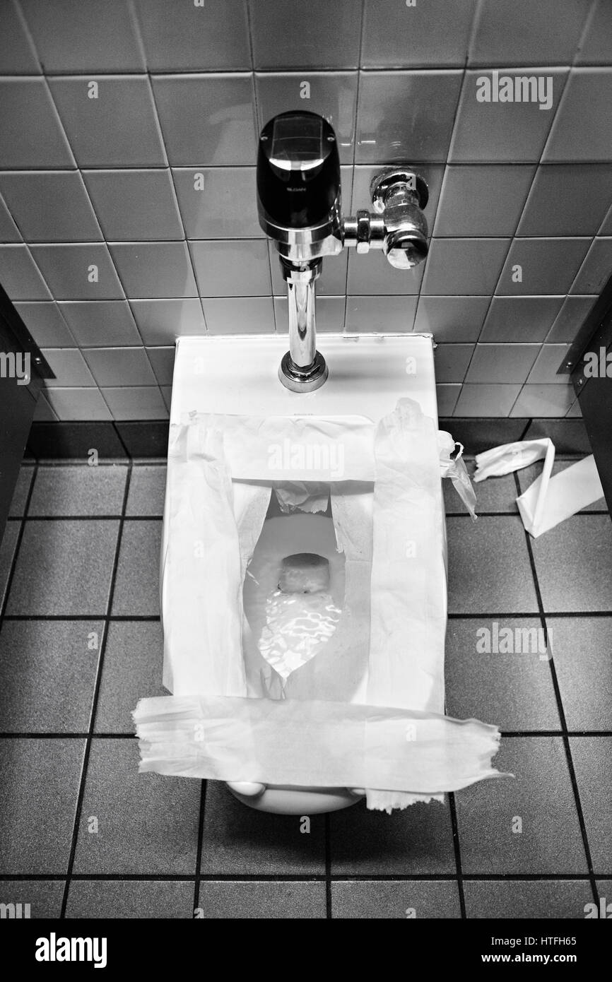 Public toilet seat covered with paper. Stock Photo