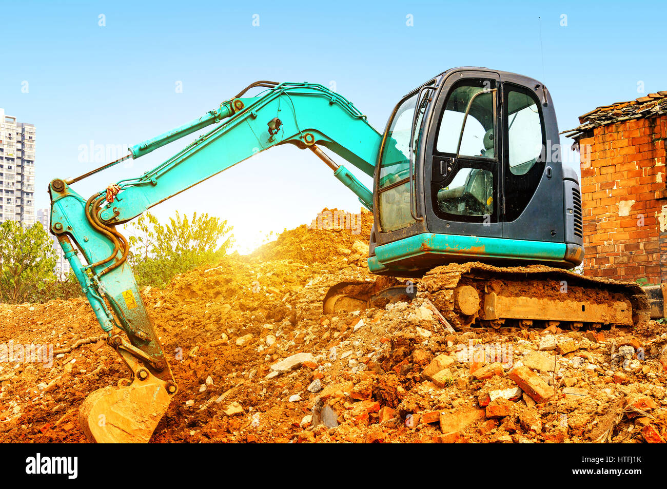 Yellow excavator on a construction site against blue sky Stock Photo ...
