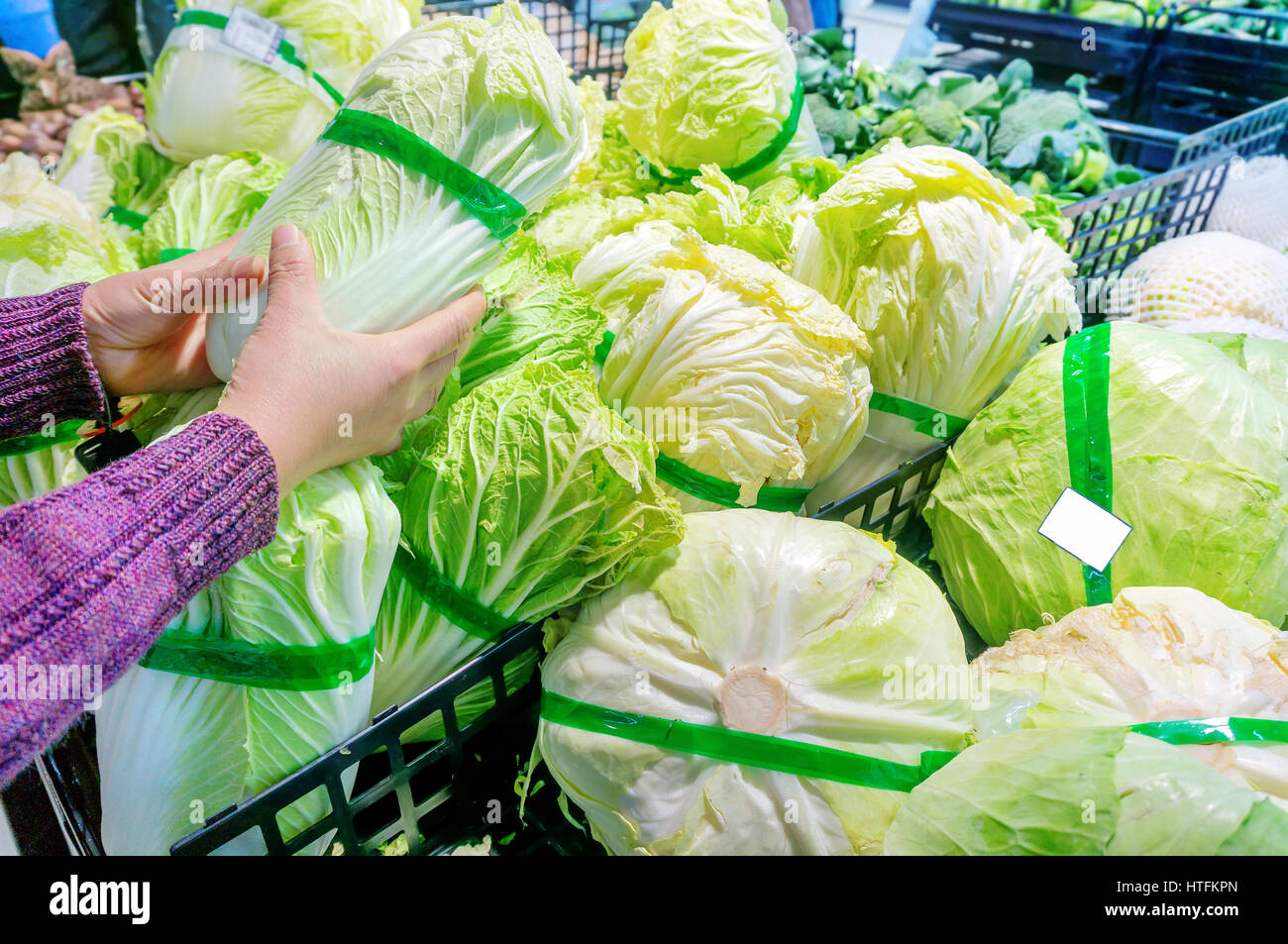 Women in the supermarket selection of fresh cabbage and cabbage Stock Photo