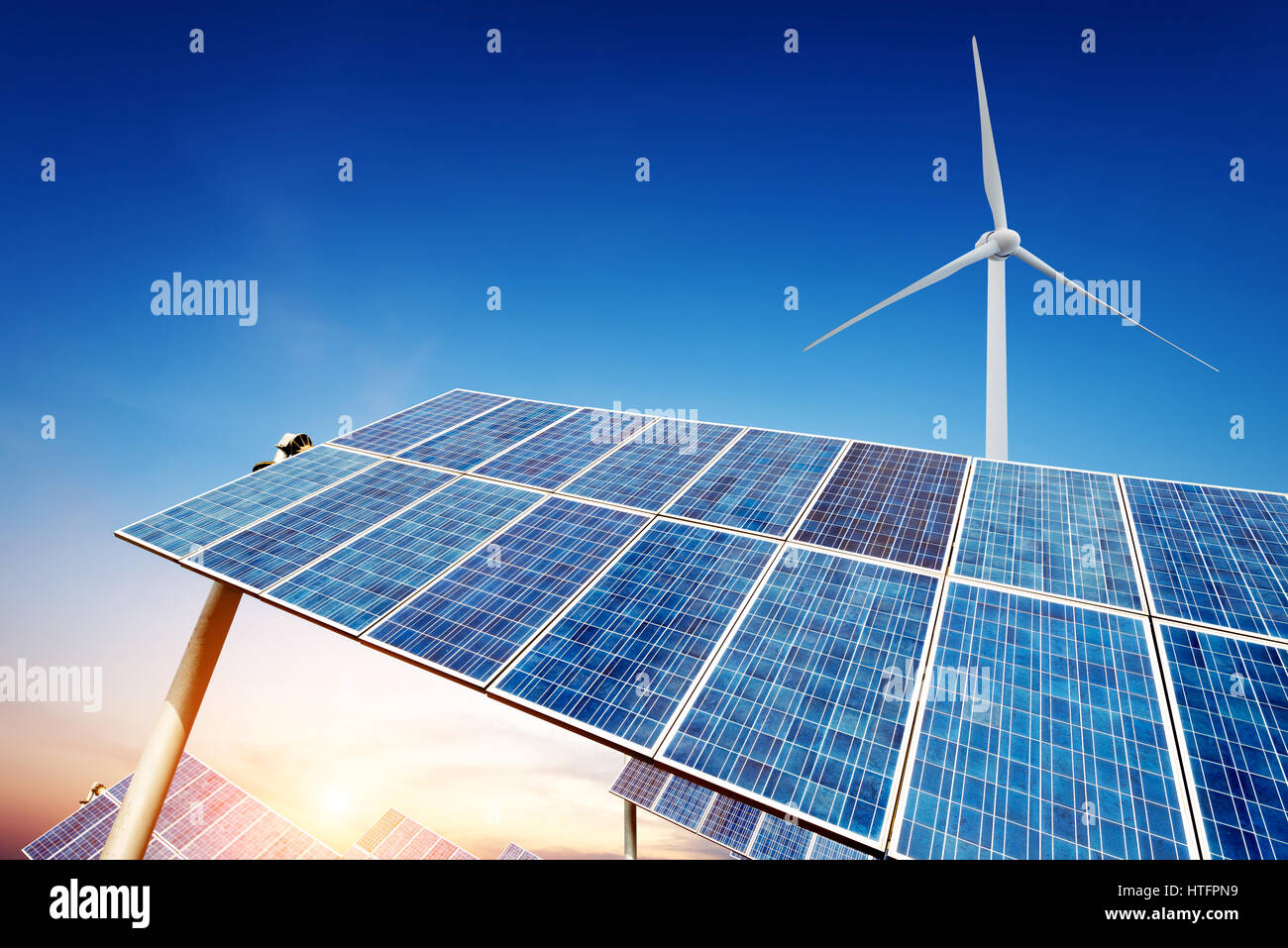 Solar panels and wind turbine against blue sky Stock Photo - Alamy