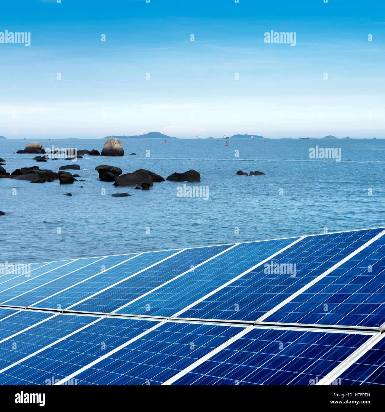 A secluded beach, there are a lot of rocks and solar panels Stock Photo ...