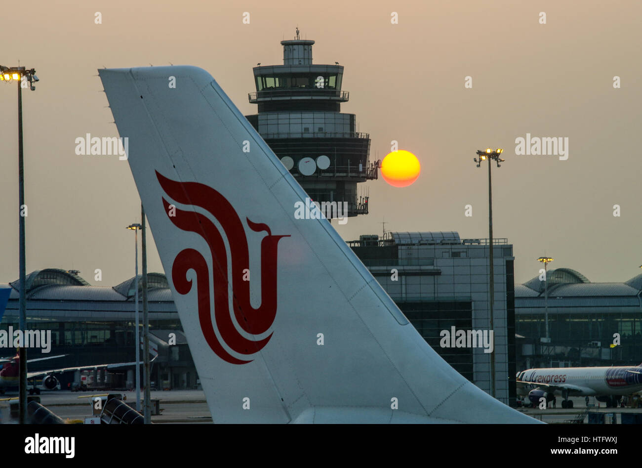 Sun setting behind the Air Traffic Control Tower in Hong Kong Chek Lap Kok Airport Stock Photo