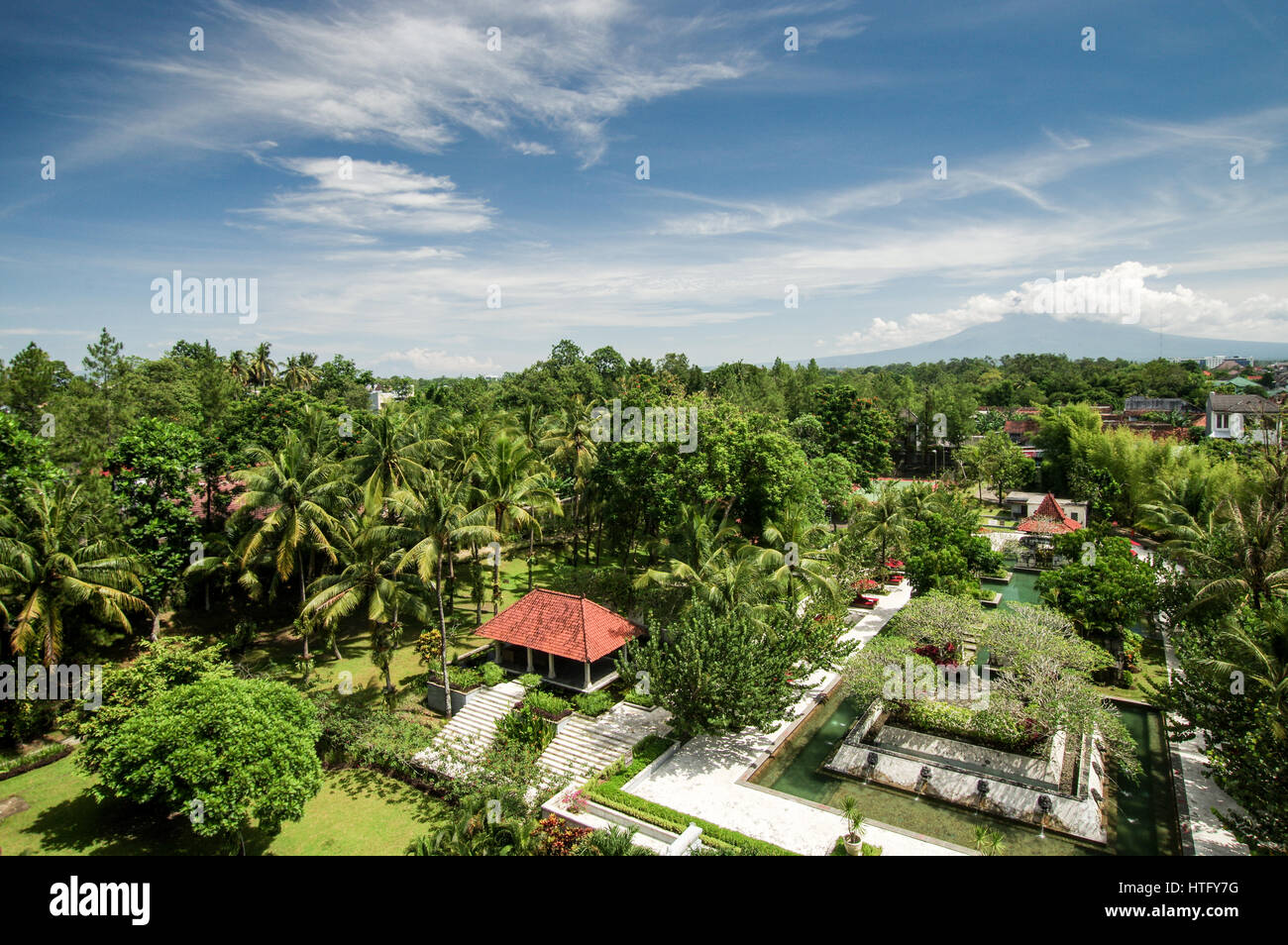 Cloud covered volcanoes Mount Merapi and Mount Sumbing seen from a hotel balcony in central Yogyakarta, Indonesia Stock Photo