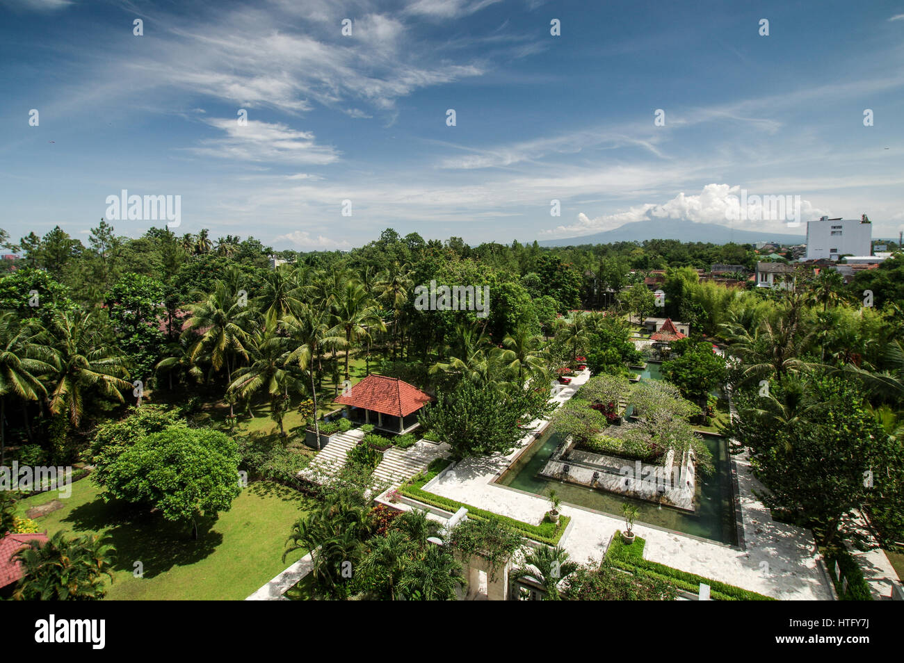 Cloud covered volcanoes Mount Merapi and Mount Sumbing seen from a hotel balcony in central Yogyakarta, Indonesia Stock Photo