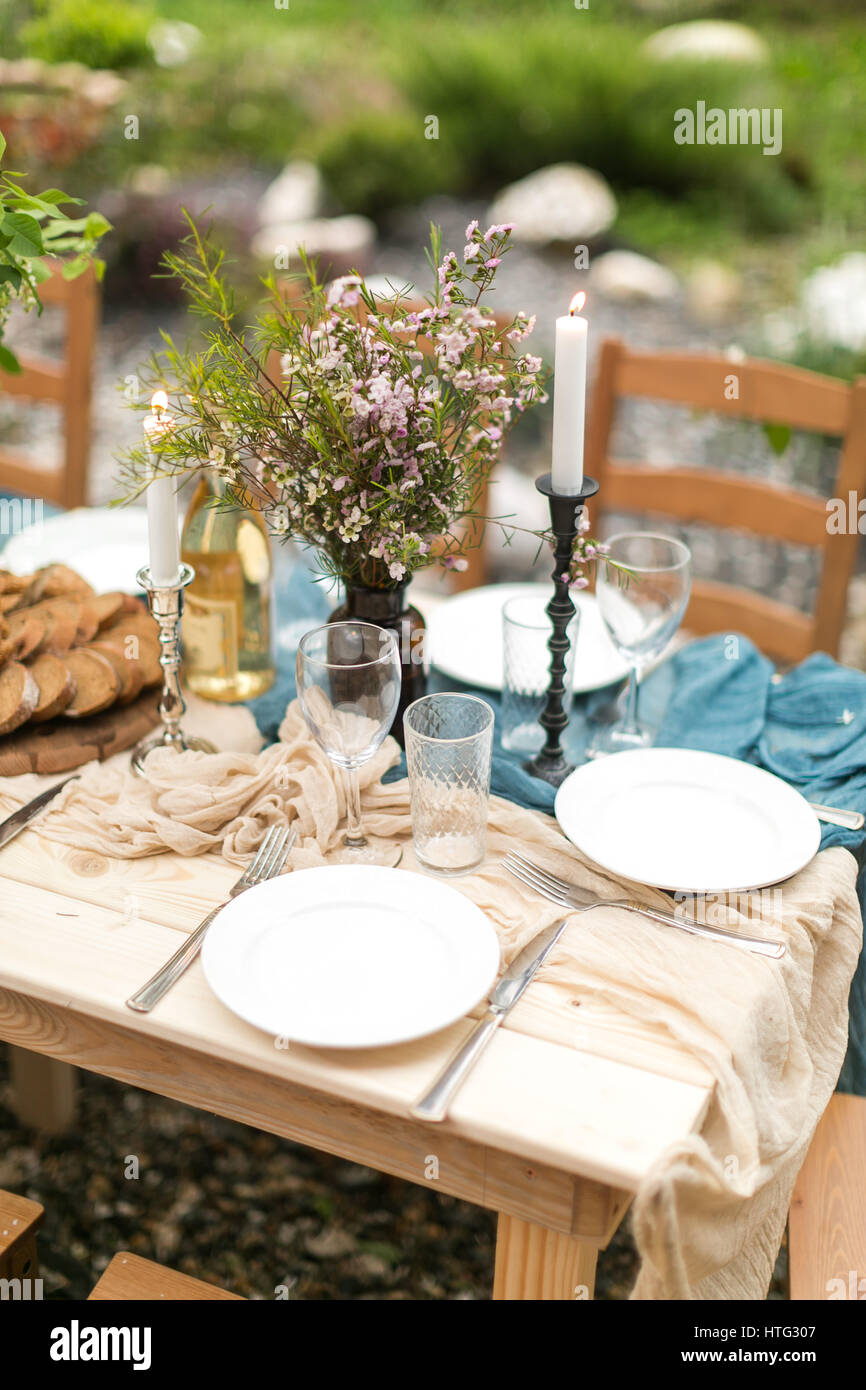 spring festive lunch an outdoors, wedding decor of a table, table layout,  the fresh cut bread, bouquet of wild flowers Stock Photo - Alamy, image size:866x1390
