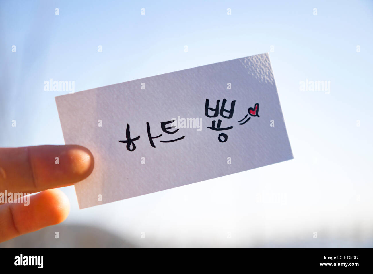 fingers hold the korean language calligraphy "heart pop! Stock Photo