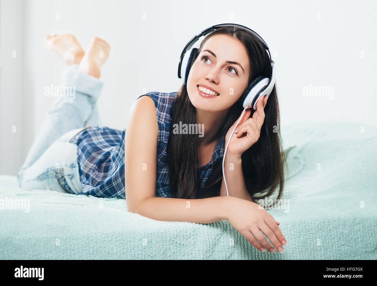 millennial girl listening music using headphones. People, leisure and technology concept. Portrait of beautiful young women in headphones. Photo with  Stock Photo
