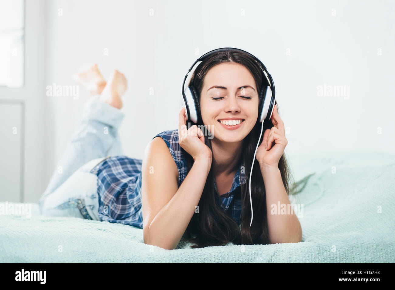 millennial girl enjoying the music at home. People, leisure and technology concept. Portrait of beautiful young woman in headphones. Caucasian woman l Stock Photo