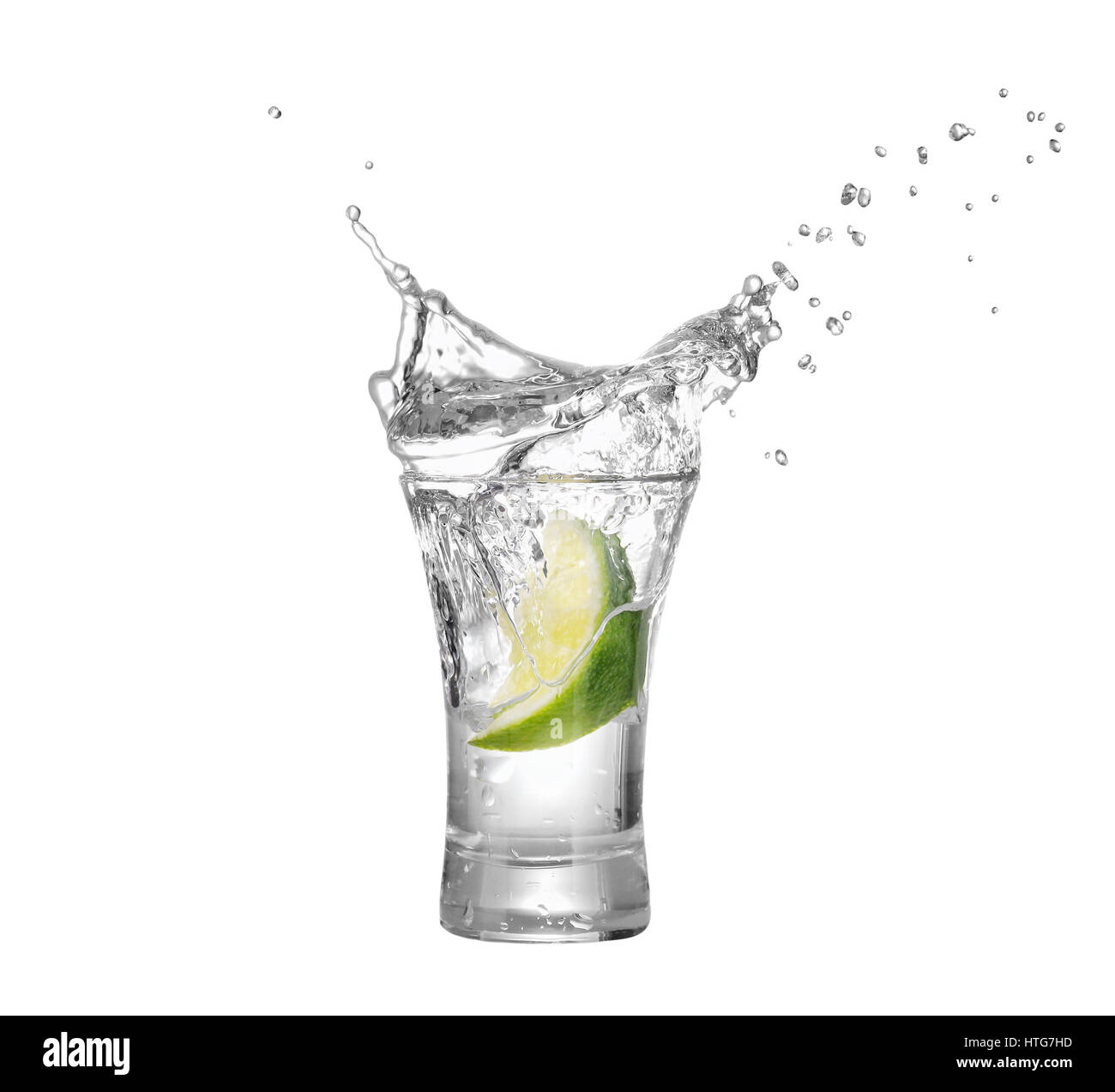 shot of vodka or tequila with lime slice and splash isolated on white