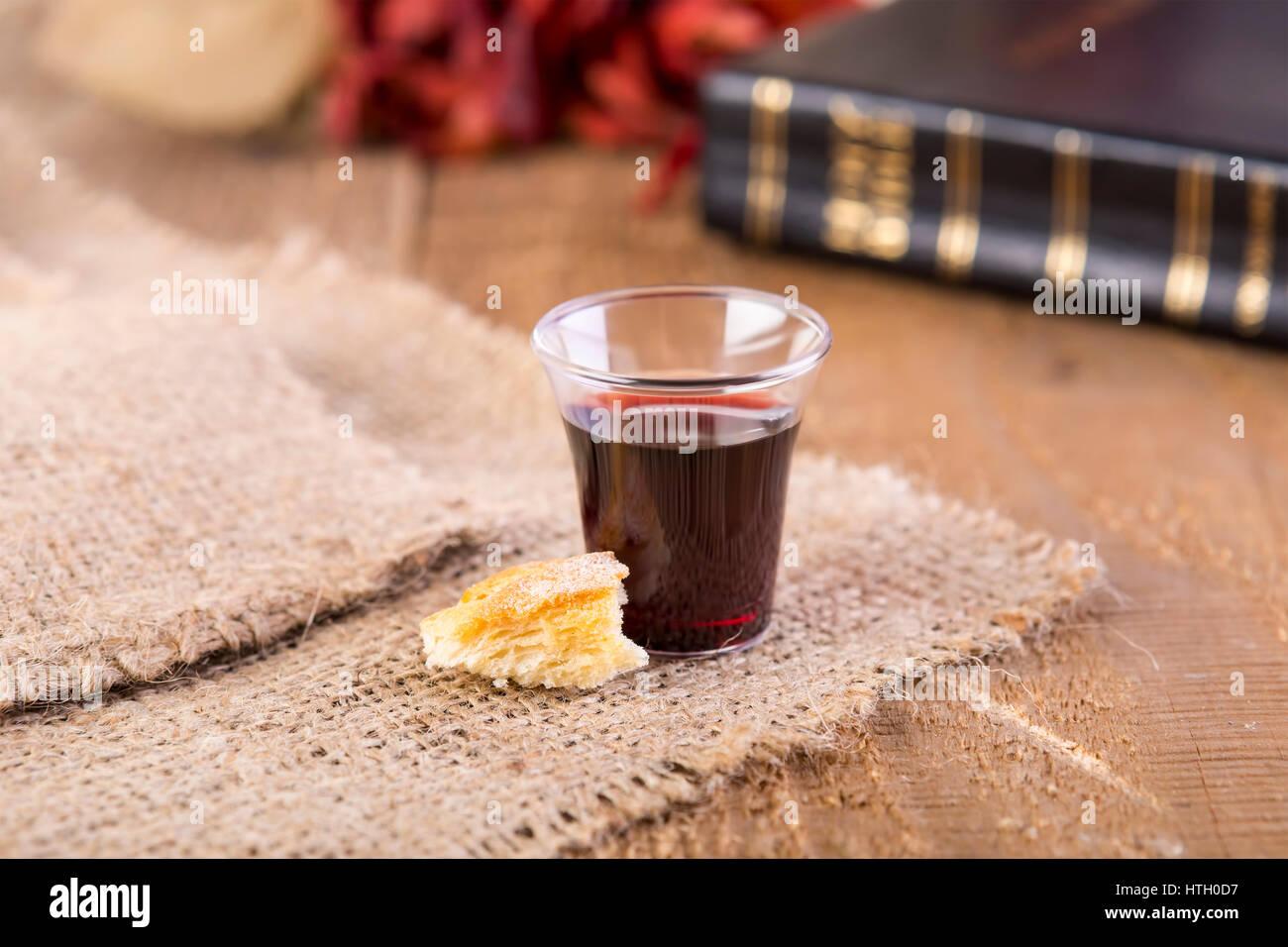 Taking Communion. Cup of glass with red wine, bread and Holy Bible on