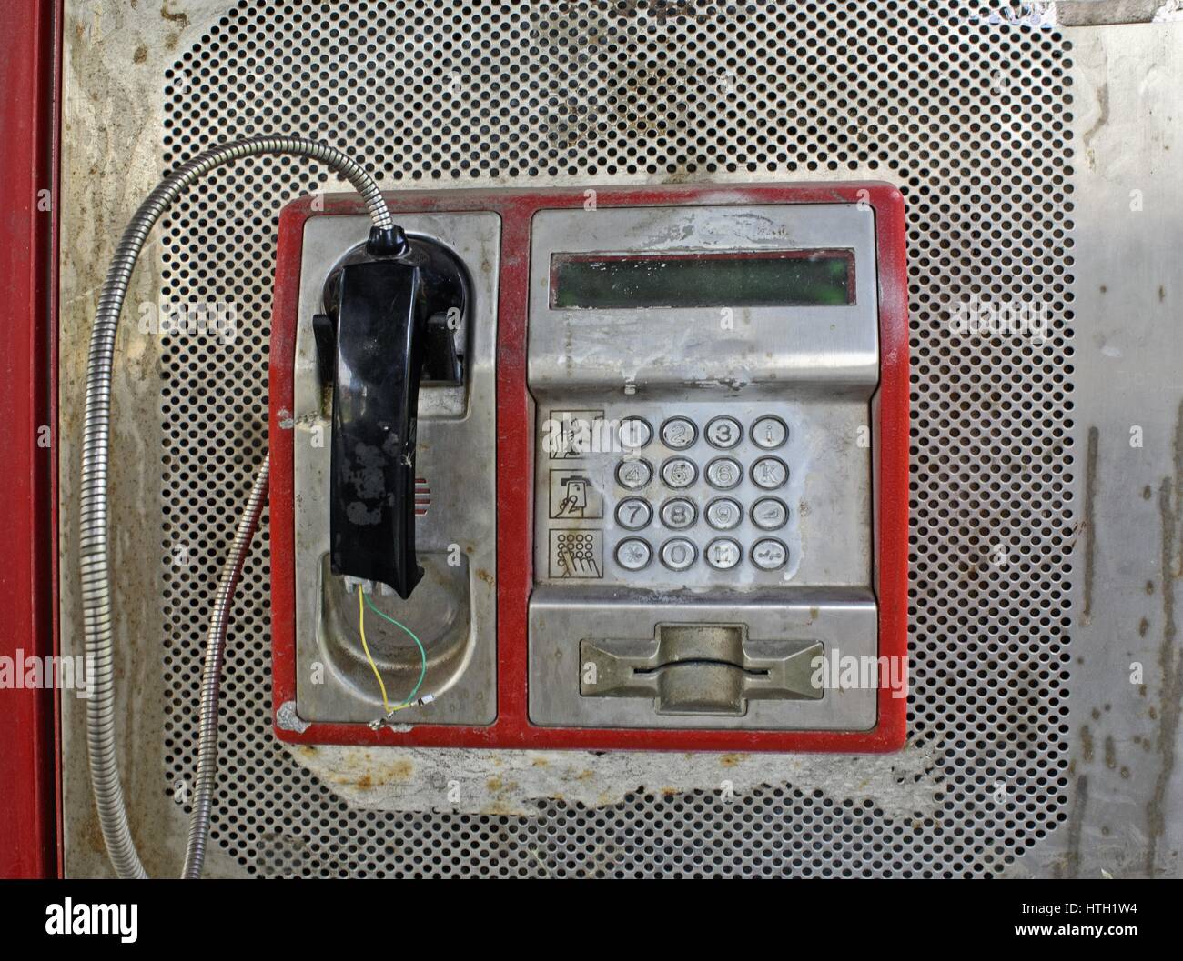 Violent damaged phone in the phone booth. Stock Photo