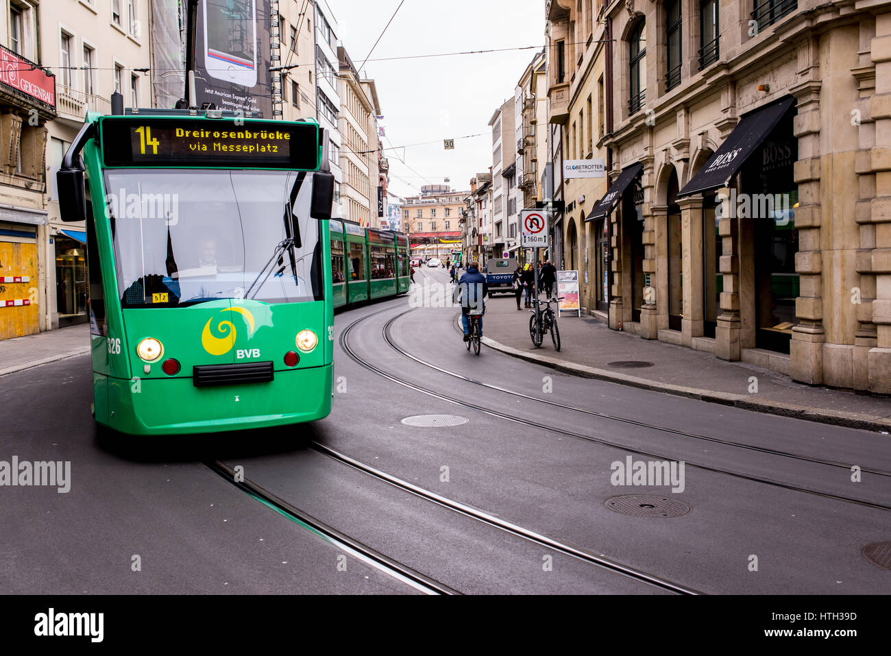 Basel, Switzerland - March 2017: Green tram in street of Basel city center. Basel's green and yellow trams have become an inseparable part of the city Stock Photo