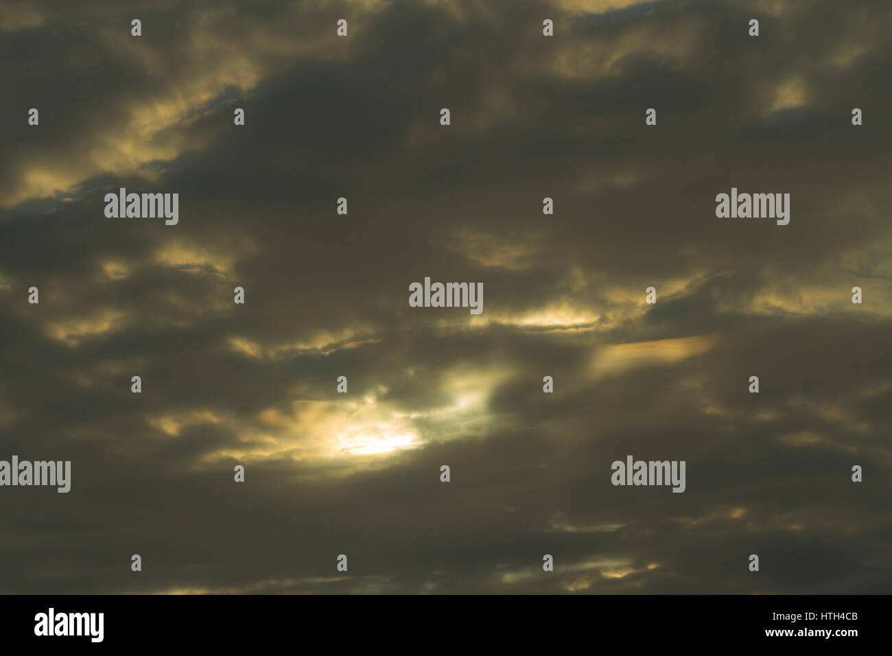 Dark clouds with the sun peeping through Stock Photo