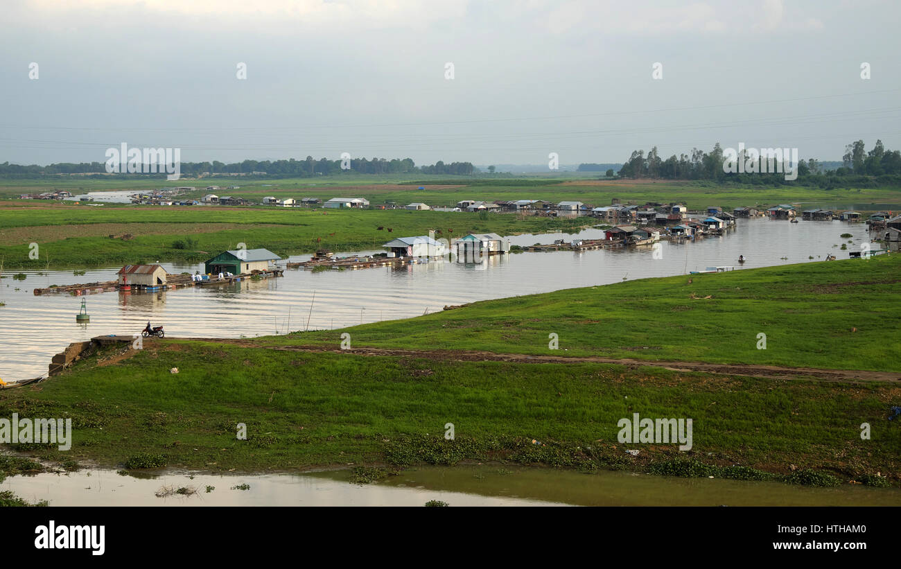 DONG NAI, VIET NAM- JUNE 5: Group of floating house on La Nga fishing village, river with green grass and hyacinth, residence of people who live with  Stock Photo