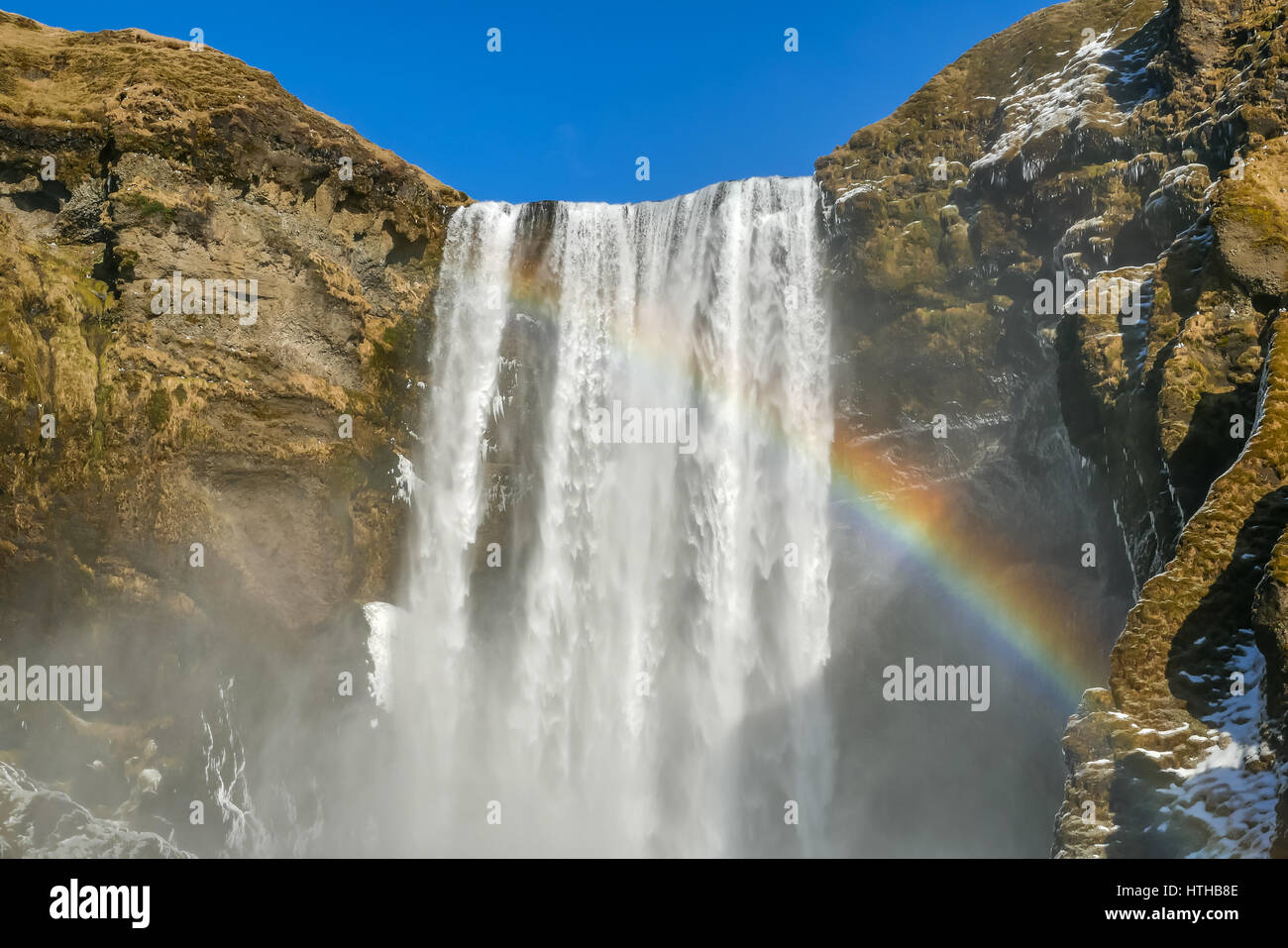 Skogafoss Waterfall, Iceland with rainbow and blue sky in Winter Stock Photo