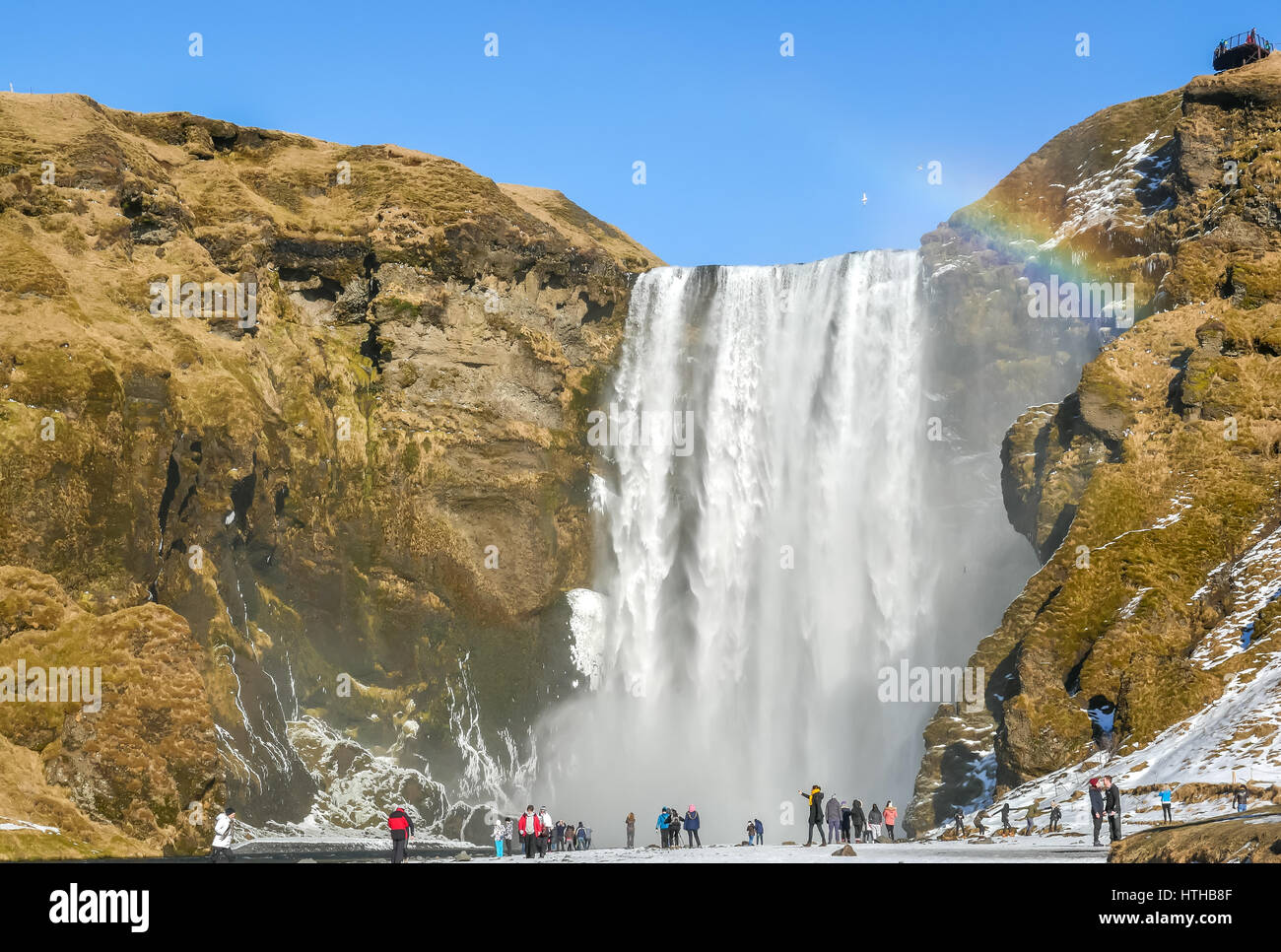Skogafoss waterfall, Iceland, with rainbow and blue sky in Winter Stock Photo