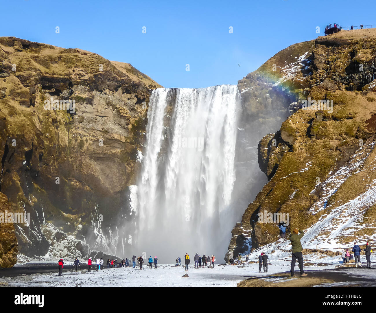 Skogafoss waterfall, Iceland, with rainbow and blue sky in Winter Stock Photo