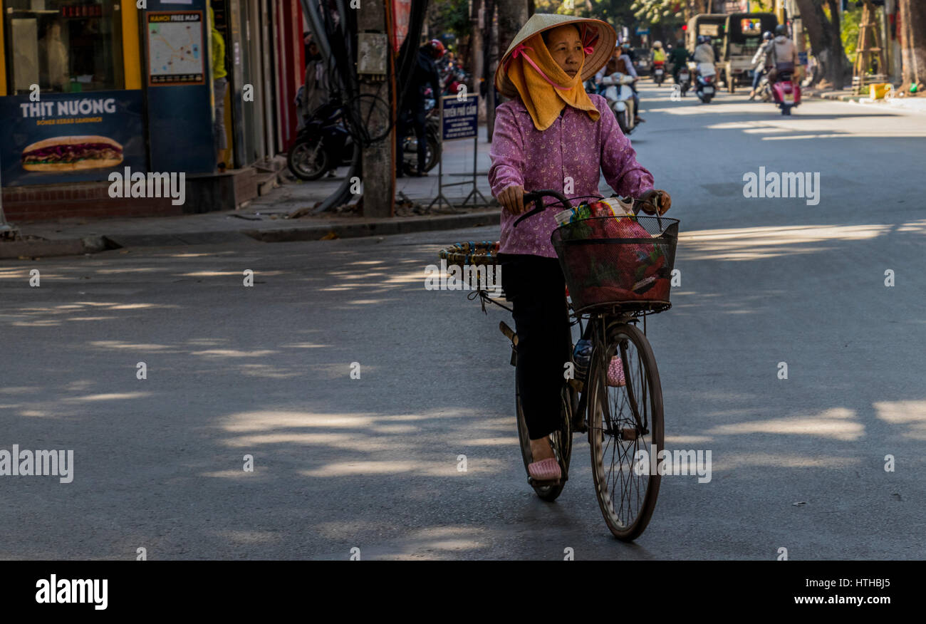 Mobile vendors at work on cycles in city of Hanoi Vietnam. They sell