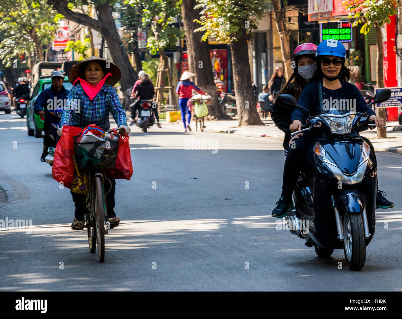 Mobile vendors at work on cycles in city of Hanoi Vietnam. They sell