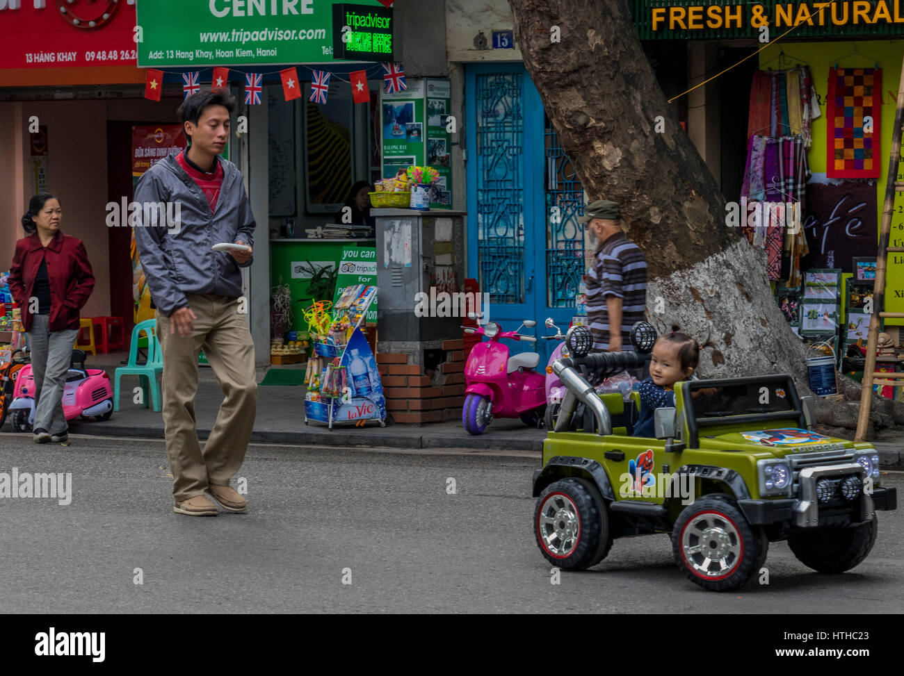 Children with parents playing on streets of Hanoi in Vietnam Stock Photo