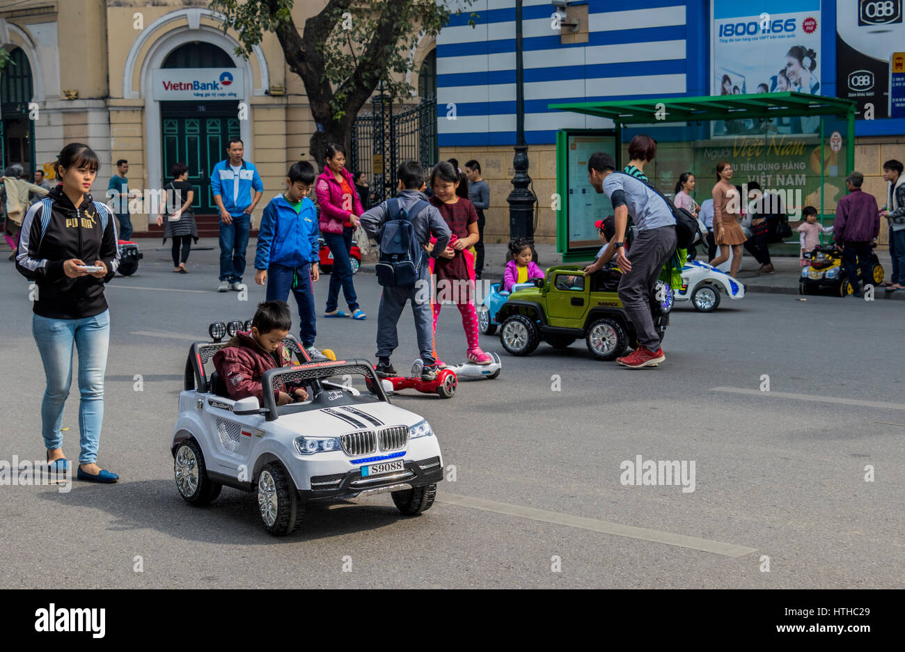 Children with parents playing on streets of Hanoi in Vietnam Stock Photo