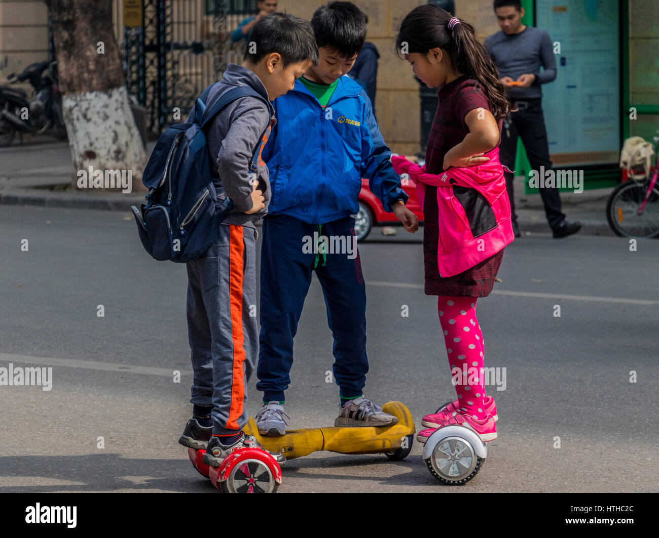 Children with parents playing on streets of Hanoi in Vietnam Stock Photo