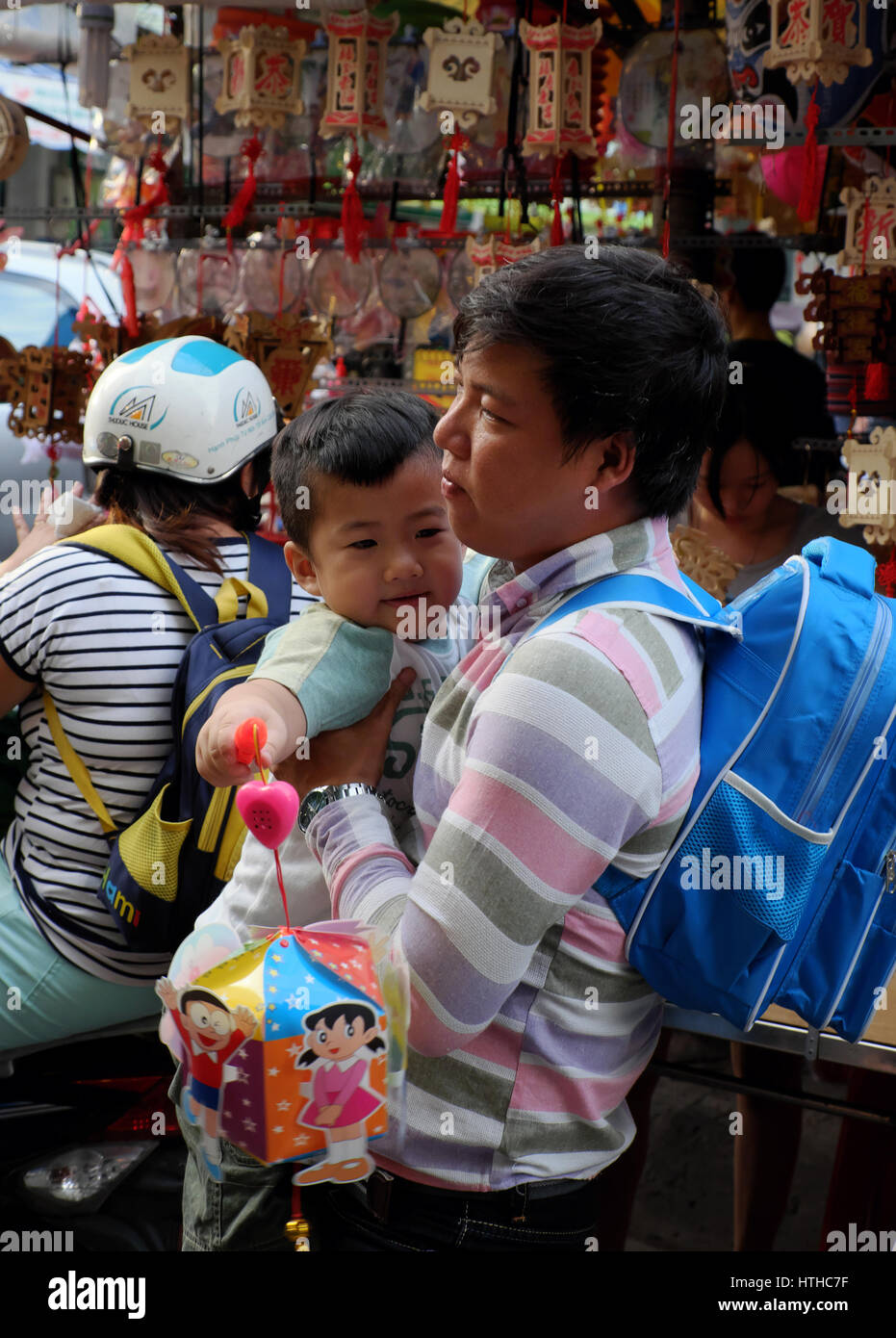 Vietnamese father visit lantern street to buy lanterns for kid on mid autumn festival, a traditional culture for children in Vietnam when full moon Stock Photo