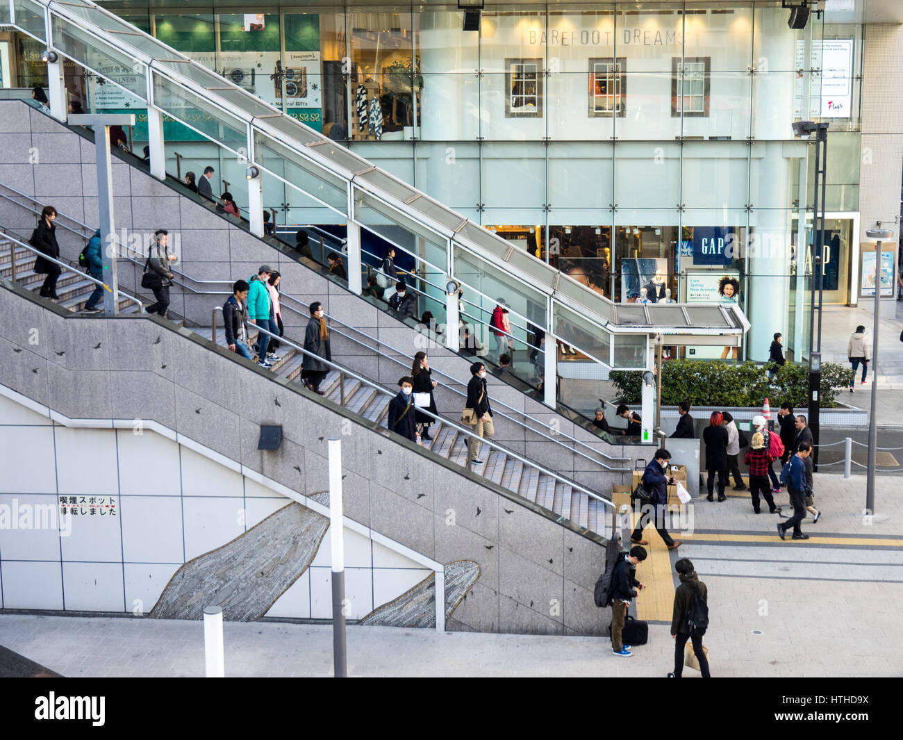 Shoppers and commuters exiting and entering Shinjuku Train Station and department stores, Tokyo, Japan. Stock Photo