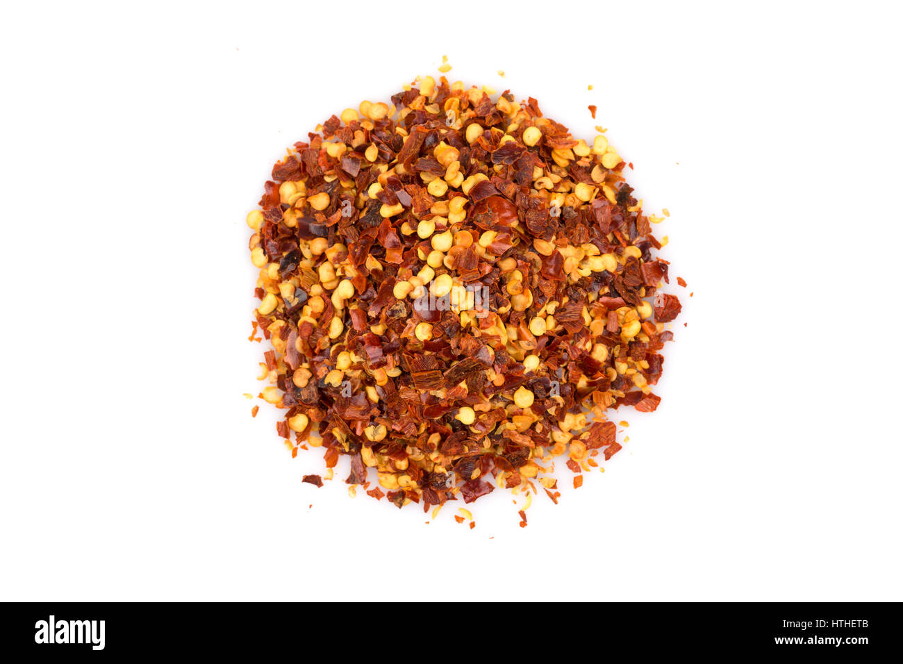 The pile of a crushed red pepper, dried chili flakes and seeds isolated