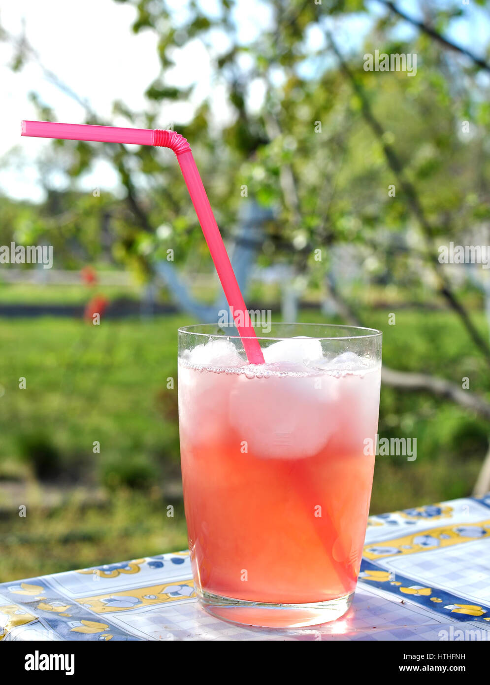 Long drink Tequila Sunrise at a rural summer garden. Stock Photo