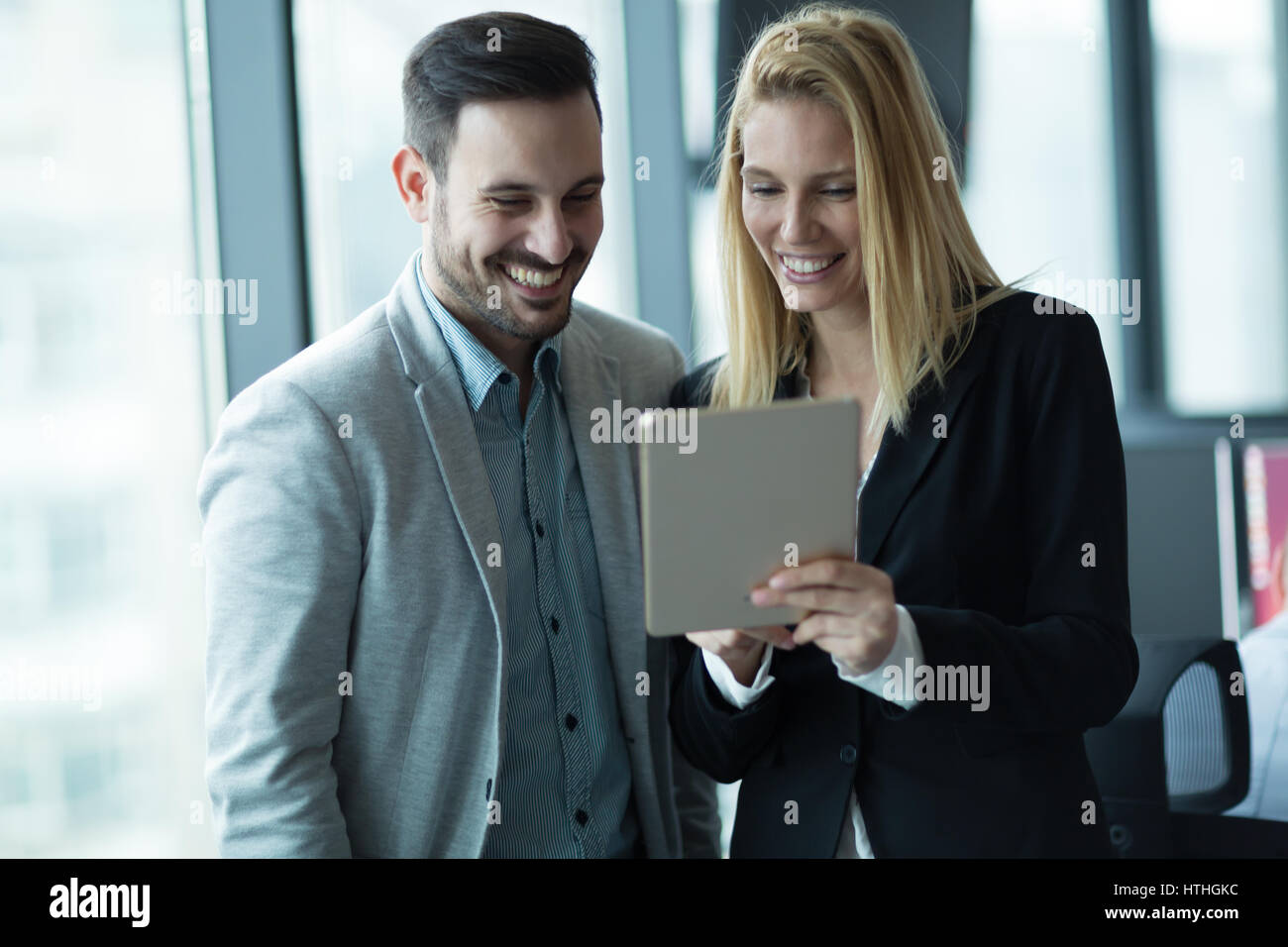 Happy business colleagues laughing together at work in office Stock Photo