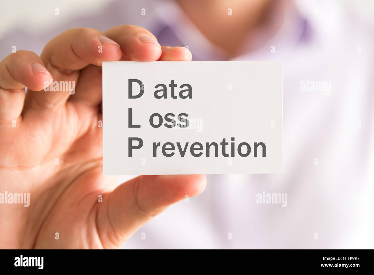 Closeup on businessman holding a card with DLP Data Loss Prevention message, business concept image with soft focus background Stock Photo