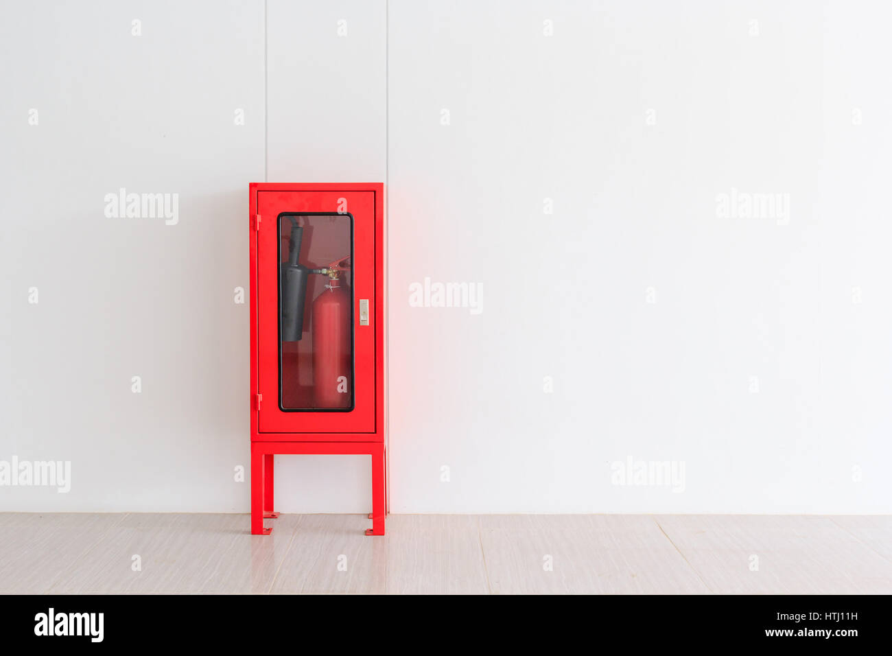 Fire Extinguisher in red Cabinet on Wall for fire protection in factory manufacturing with copy space. Stock Photo