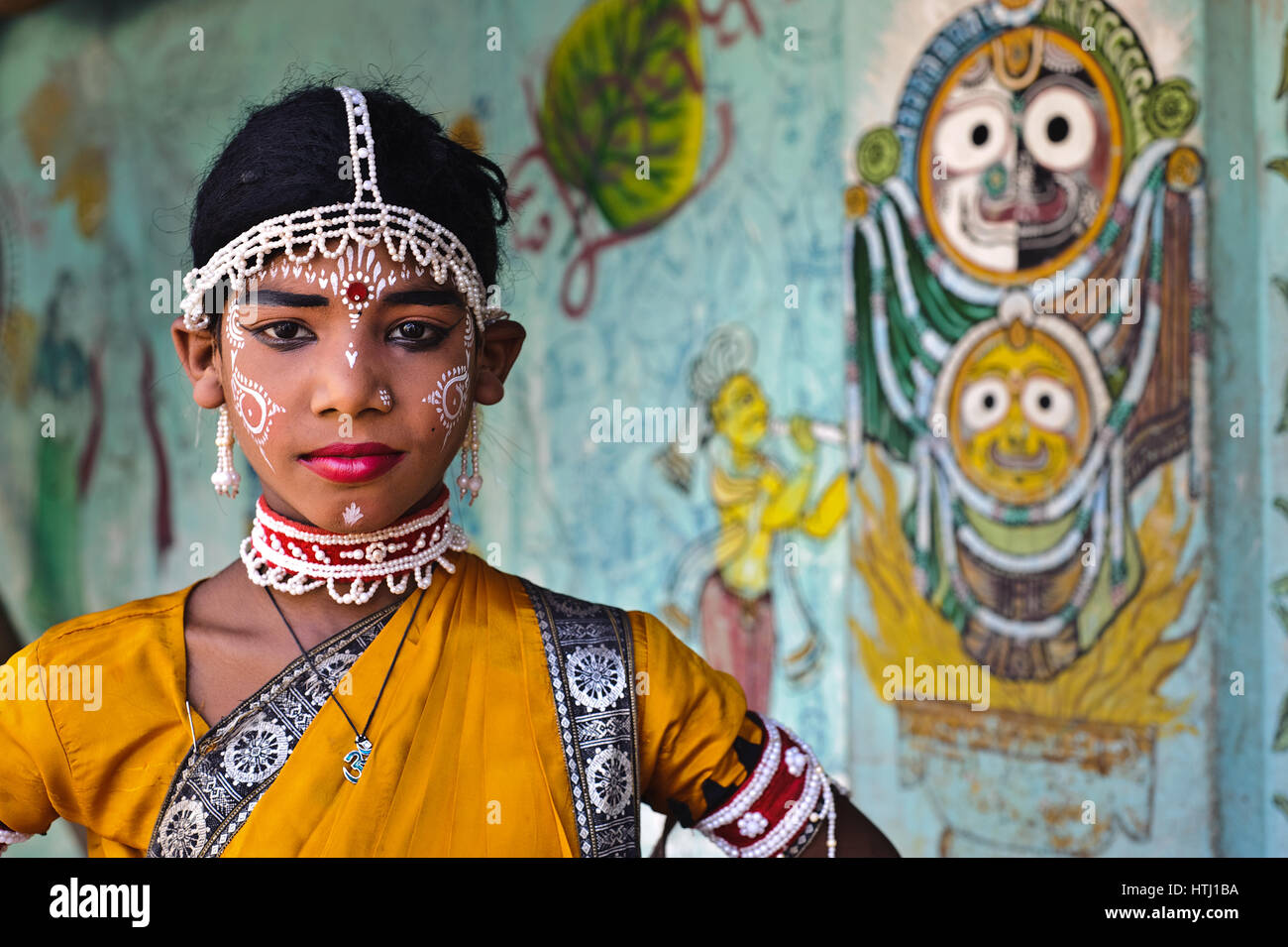 Gotipua dancer ( India) In the background, mural painting of the hindu gods Jagannath and Subhadra. Stock Photo