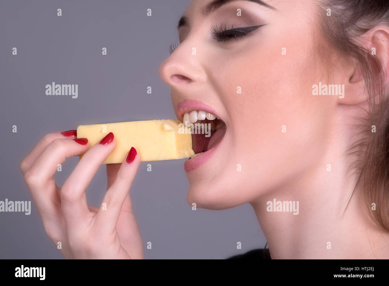 Woman eating a piece of Cheese Stock Photo