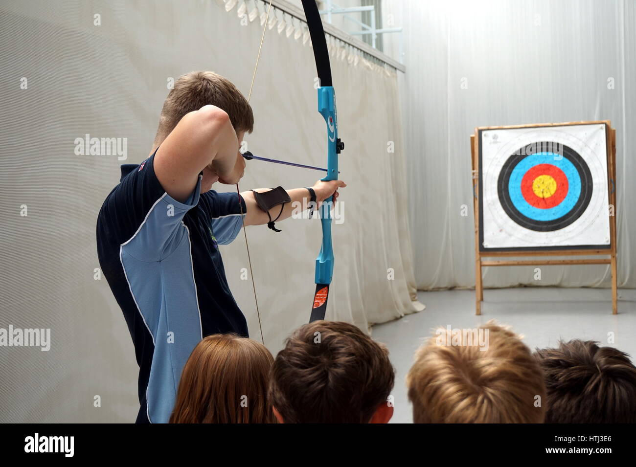 SURREY, ENGLAND, UK, JUNE 11 2016 Archery instructor shows four