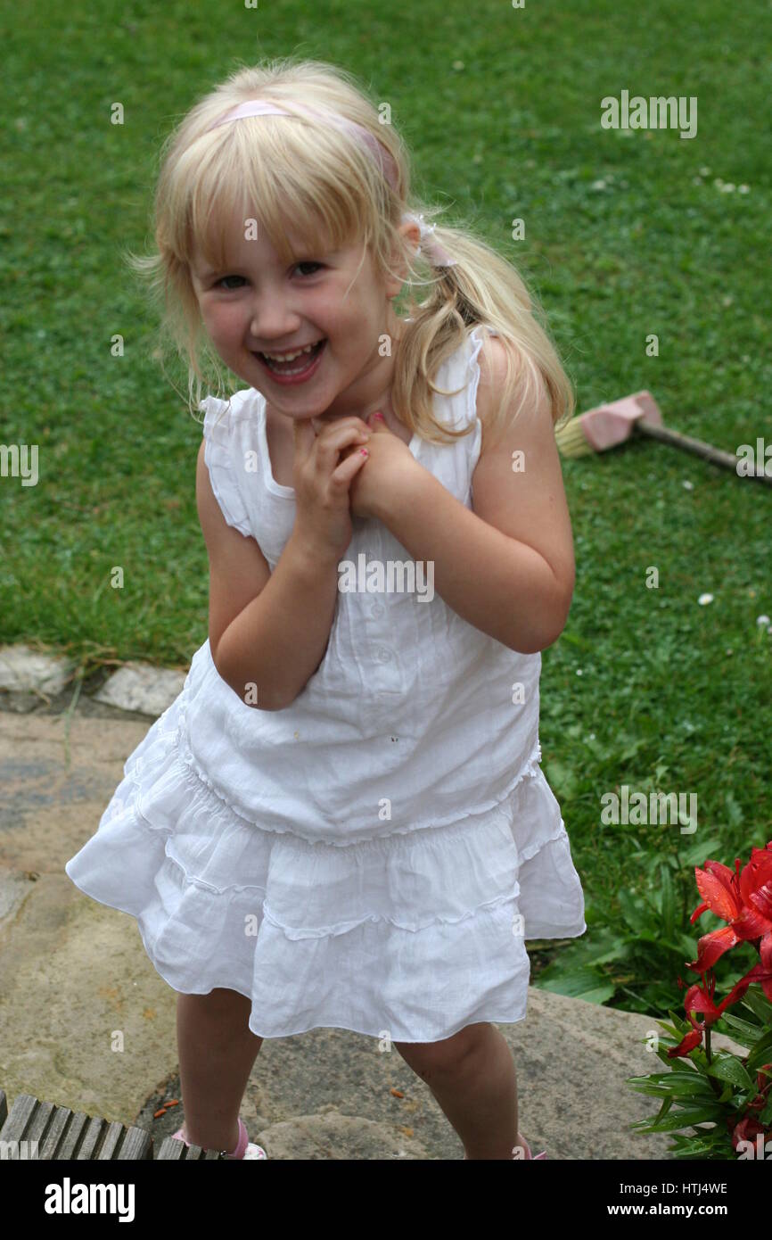 little girl child kid blonde hair in ponytail white summer dress laughing  and giggling in the garden, joy concept, happiness is, happy child Stock  Photo - Alamy