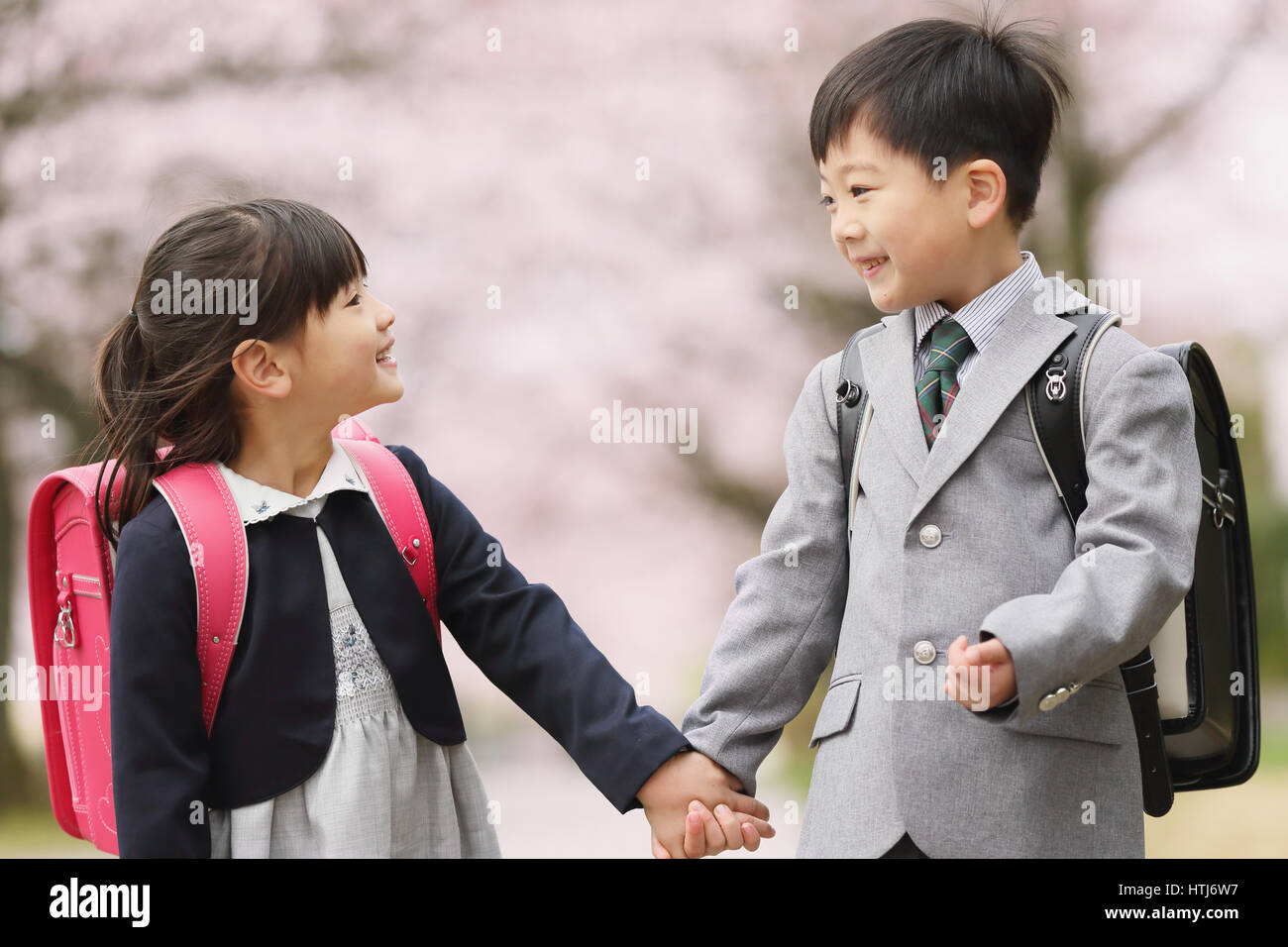 Japanese kids with cherry blossoms in a city park Stock Photo