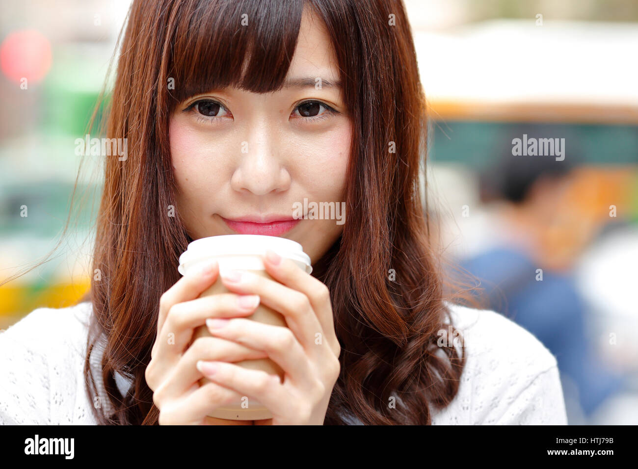 Fashionable Japanese woman with coffee in luxury Tokyo area, Tokyo, Japan Stock Photo