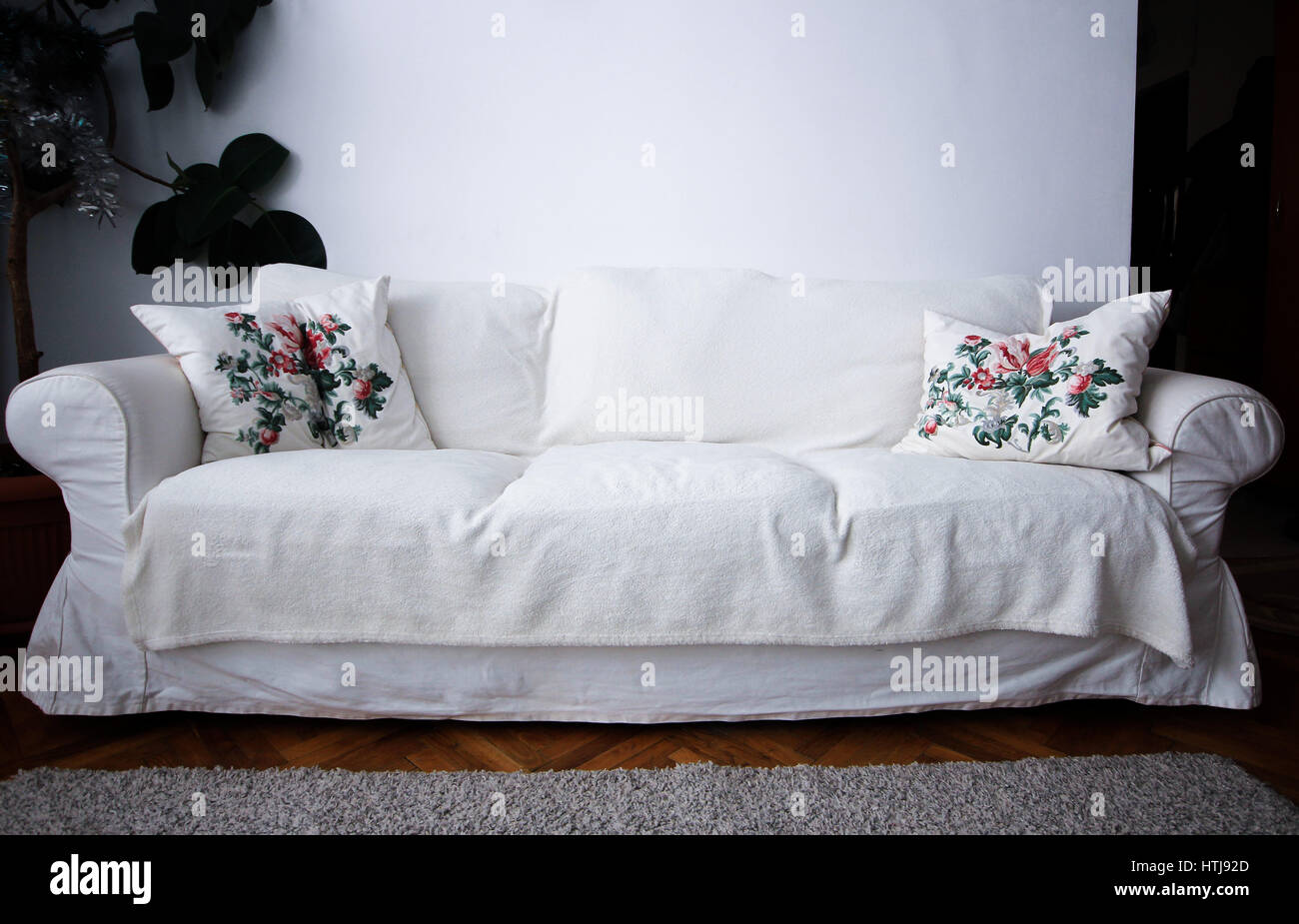 White living room couch with pillows and plant Stock Photo